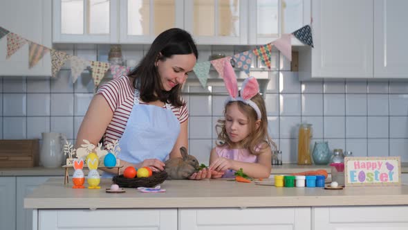 Little Girl with Mom Feeding Little Easter Rabbit alt