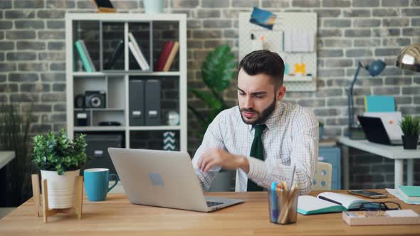 Portrait of Tired Guy Working with Laptop in Office Then Sleeping on Table alt