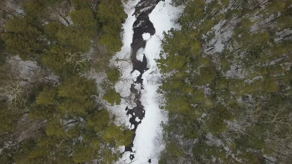 Top down drone shot of river in a winter wonderland alt