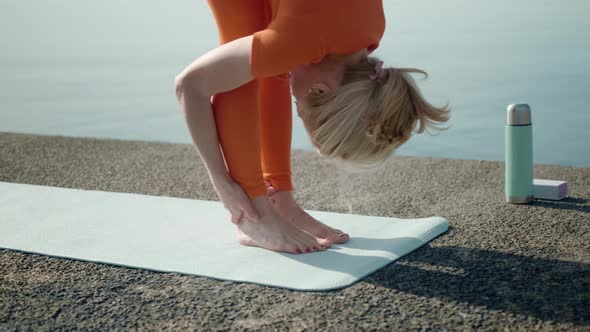Flexible Woman Leaning to Legs Stretching Morning Workout at Sea alt