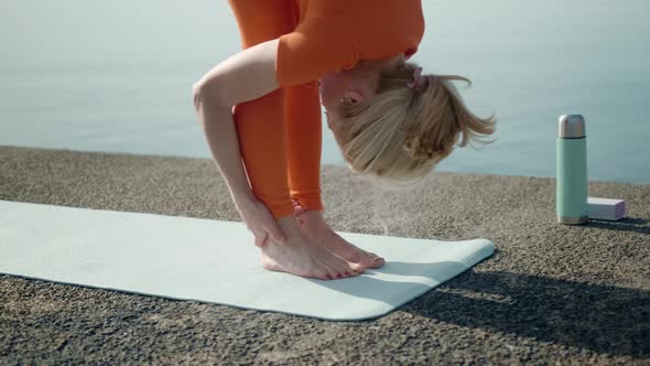 Flexible Woman Leaning to Legs Stretching Morning Workout at Sea
