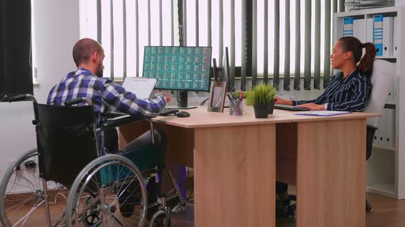 Paralysed Financial Expert Sitting in Wheelchair Analysing Economy alt