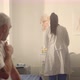 Elderly Man Holding Shoulder After Vaccine in Clinic Closeup - VideoHive Item for Sale
