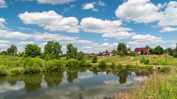 Village Landscape with a Small Lake, Time Lapse of Clouds Reflected in the Water, Beautiful Summer alt