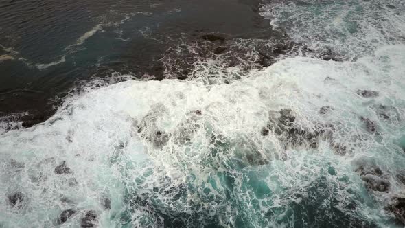 Bird's Eye View of Waves Crashing on a Rocky Coast alt