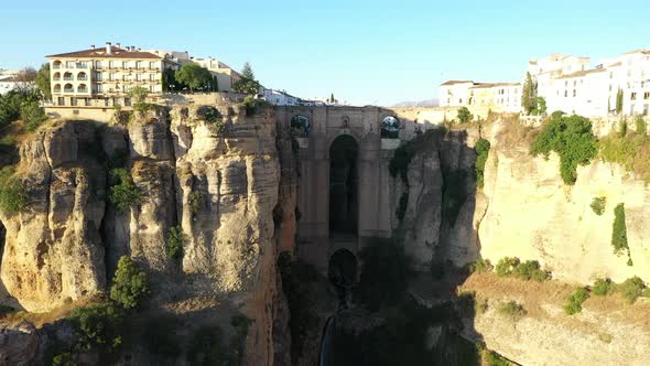 AERIAL - Epic view of old bridge, Ronda, Malaga, Spain, wide shot rising forward alt