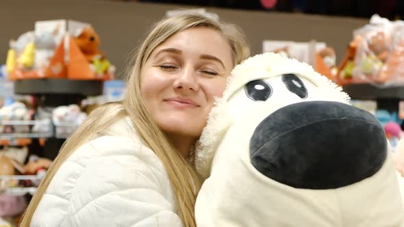 A Beautiful Young Girl Hugs a Big Soft Toy Dog alt