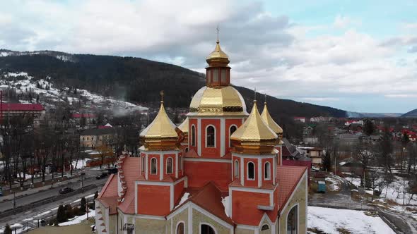 Aerial Drone View of Ukrainian Church with Golden Domes in Carpathian Village in Winter alt