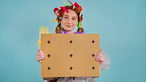 Girl with plastic garbage on herself holding placard with tracking points.