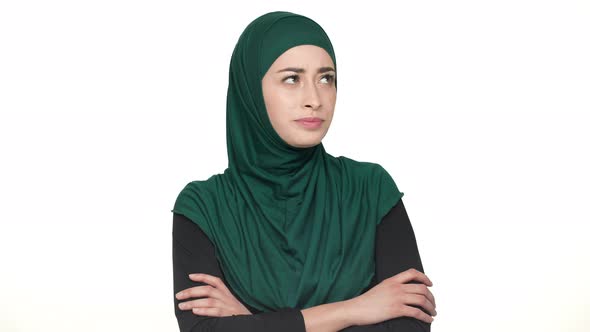 Portrait of Attractive Woman in Religious Headscarf Standing with Hands Folded and Expressing alt