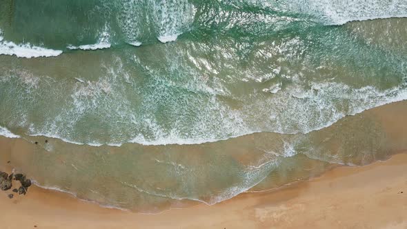 Aerial view of white sand beach and ocean wave alt