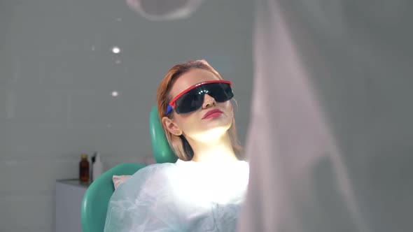 Beautiful girl in dark glasses at a reception in a dental clinic