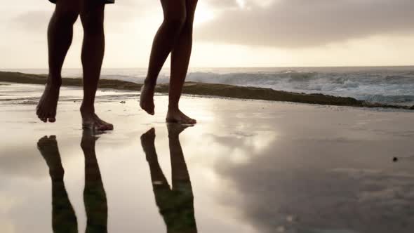 Couple walking together on concrete pier on beach at dusk 4k alt