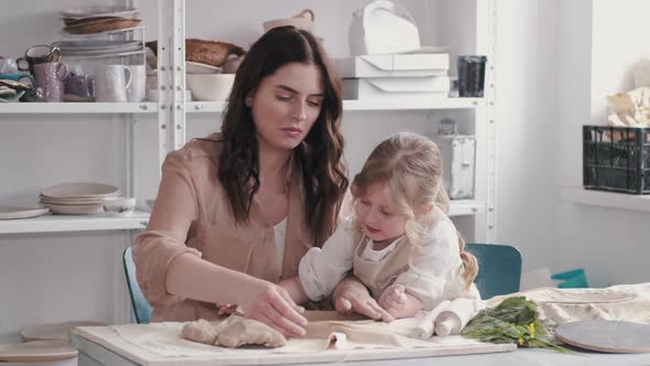 Portrait of Mother and Little Girl Shaping Clay Together alt
