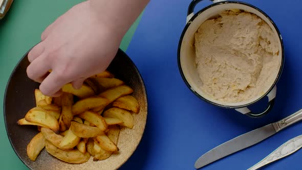 Vertical Tabletop Video Man Scoops Up Cheese Sauce with Crispy Potato Wedges