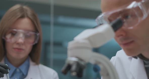 Team of Young Scientists Is Working in Pharmaceutical Laboratory, Woman Is Exploring Reagents and alt