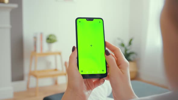 Young Female Using Smart Phone Sitting On Sofa At Home.