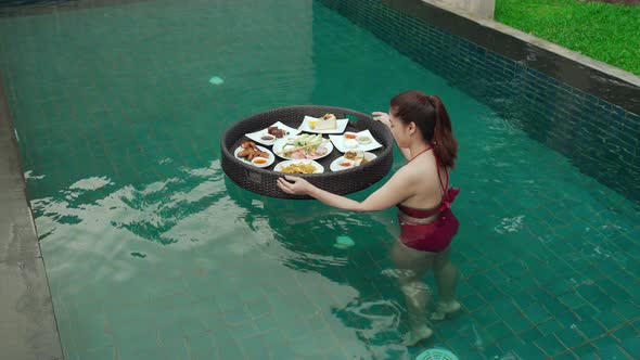 young woman enjoying with floating food in swimming pool