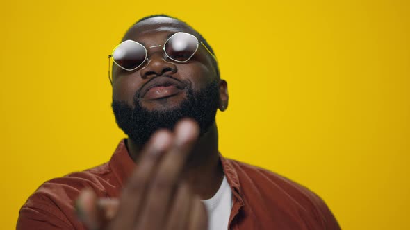 Portrait of Smiling African American Man Showing Come to Me Gesture in Studio alt
