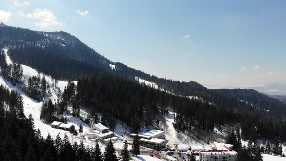 Raising up and rotating to reveal the ski slope at Poiana Brasov covered with snow alt