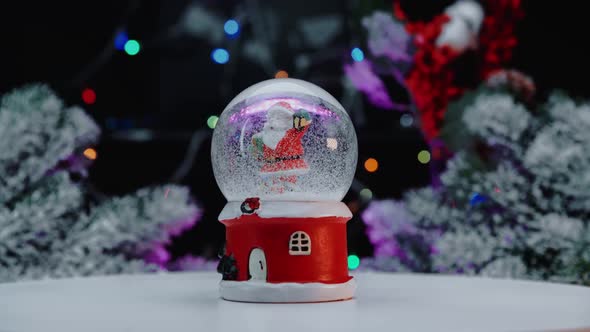 Christmas snow glass ball on the background of a Christmas tree with Christmas lights.