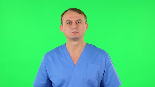 Medical Man Listens Attentively and Nods His Head Pointing Finger at Viewer. Green Screen alt