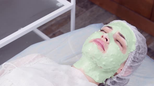 Beauty and Cosmetology Concept. Young Woman with Cream Mask in a Beauty Parlour alt