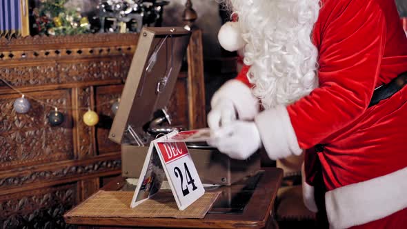 Santa Claus is turning a calendar page. Close up of Santa Claus with calendar.  alt