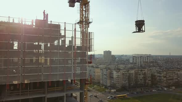 Raising a Cistern with Concrete on the Roof of a Highrise Building Under Construction with Workers