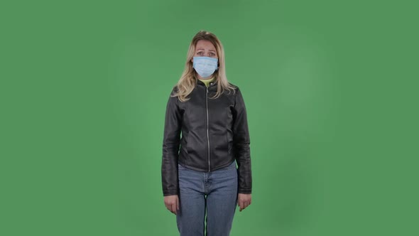 Portrait of Beautiful Young Woman in Medical Protective Face Mask Looking at Camera Worries  alt