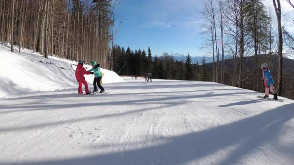 First-person View on Skiers and Snowboarders Slide Down on Ski Slope at Ski Resort alt