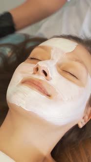 Cosmetologist Applies Mask to Skin of Woman's Face for Therapeutic Purposes alt