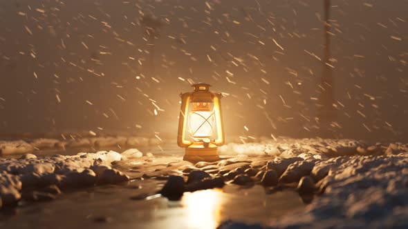 Old vintage hand lantern warming a frozen surrounding during a winter blizzard. alt