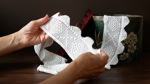 Woman is examining a beautiful vintage crisp white lace ribbon