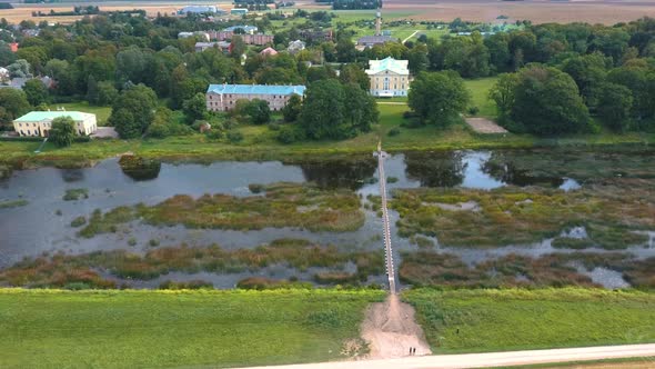 Mezotne Palace and Park With Fountain in Latvia. Lielupe River With Ponton Bridge Aerial 4K alt