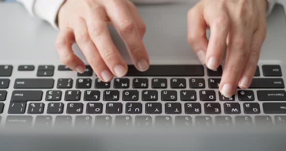 Female fingers are typing text on the laptop keyboard. Business woman works using a computer. alt