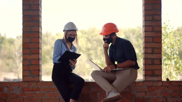 Engineer In Face Mask Cooperating Together On Workplace. Architect Working Together In Lockdown. alt