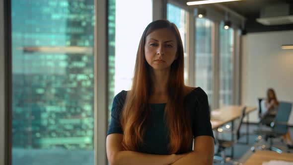 Portrait of Young Successful Redhair Businesswoman Standing in Office Hall Looking at Camera alt