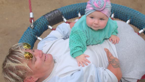 Disabled person with baby, lifestyle outdoors. Congenital amputations.