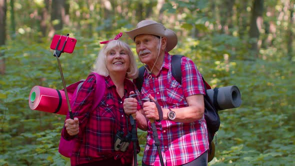 Senior Grandmother Grandfather Blogger Tourists Taking Selfie Photo Portrait on Smartphone in Forest alt