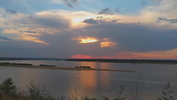 Timelapse of a Beautiful Sunset Over a River with Sky and Clouds Light Reflections in the Water