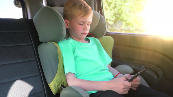 Child Using Smart Phone in Car Hands Typing on Mobile Phone