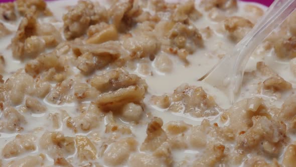 Milk and corn flakes mixed for natural breakfast slow tilt 4K 2160p 30fps UltraHD footage - Muesli c alt