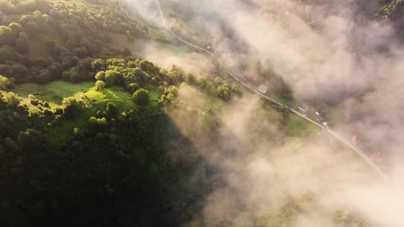 Fog Morning Over the Hill and River of the Meadow Near a Rural Village with a House Aerial View alt