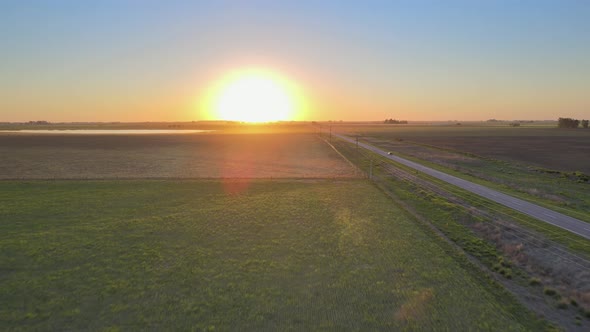 Road running through the Pampas in La Pampa, Argentina, sunset drone alt