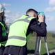 Confident Architect Looking Away with Theodolite As Blurred Engineer with Binoculars Standing at - VideoHive Item for Sale