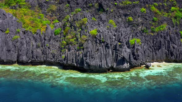 Clear Waters and Jagged Limestone Cliffs of Matinloc Island at Palawan, Philippines alt