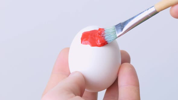 Closeup of a Person Painting Easter Eggs with a Special Brush alt