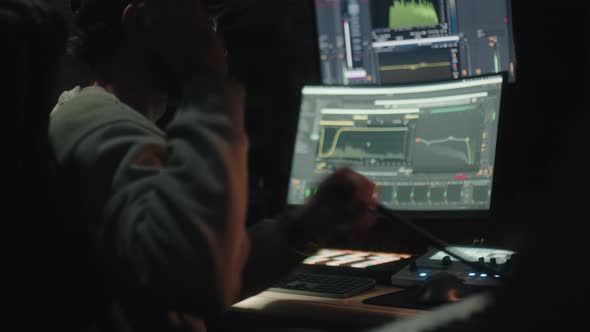Sound Engineer Seen Seated From Behind Uses the Computer to Mix Audio Music alt