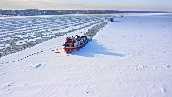 Icebreakers on river in winter. Aerial view of frozen river. alt